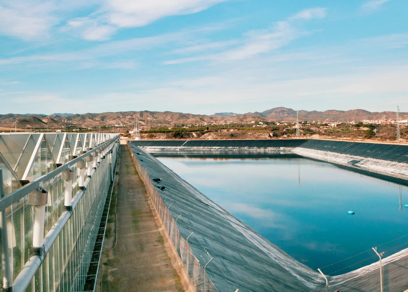 Embalse de agua junto a los invernaderos